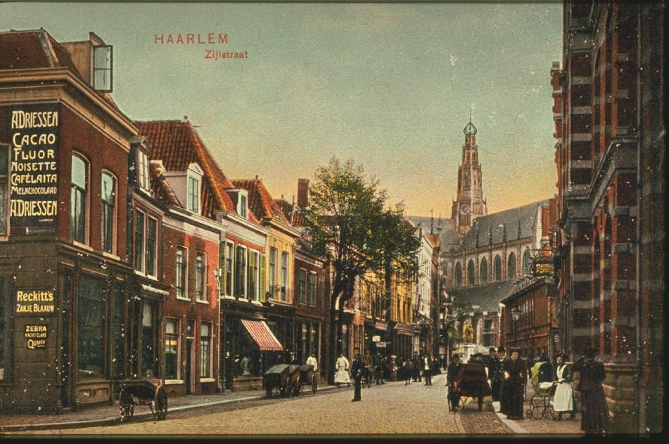 Vintage pohlednice ulice Zijlstraat v Haarlemu s chodci, koňskými povozy a historickými holandskými budovami.